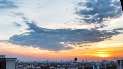 View of cityscape against cloudy sky