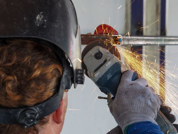 Close-up of man grinding metal at workshop