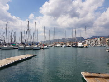 Sailboats moored at harbor