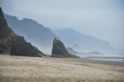 Scenic view of mountain by sea against sky