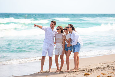 Rear view of couple standing at beach