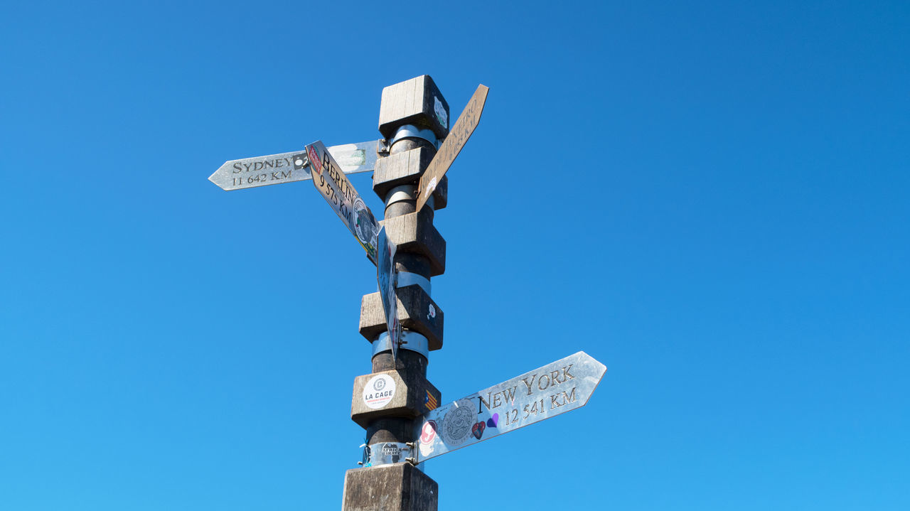 blue, sky, clear sky, communication, sign, nature, guidance, no people, arrow symbol, low angle view, directional sign, day, symbol, sunny, copy space, cross, outdoors, road sign, business, lighting, machine