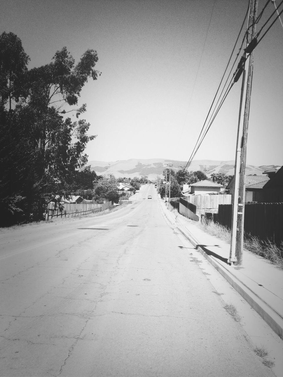 clear sky, transportation, the way forward, copy space, diminishing perspective, road, mode of transport, sky, vanishing point, built structure, tree, street, day, empty, car, outdoors, nature, tranquil scene, no people, house