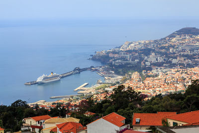 High angle view of townscape by sea against sky