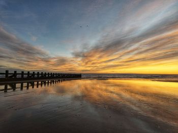 Bridge over river against sky during sunset