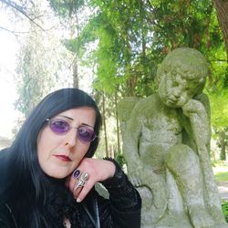 Portrait of young woman against plants