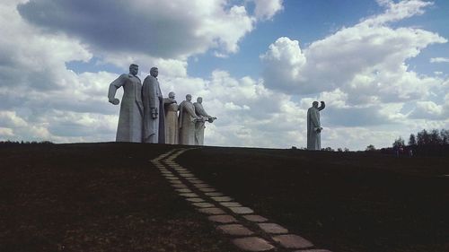 Statue on road against sky