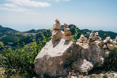 Stack of rocks against sky on sunny day