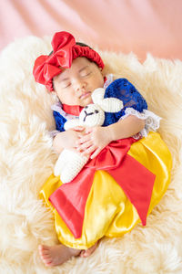 Portrait of cute baby girl lying on bed