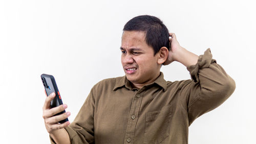 Portrait of man using smart phone against white background