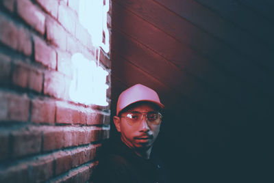 Portrait of young man looking away against wall