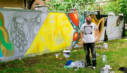 Man standing against graffiti on wall