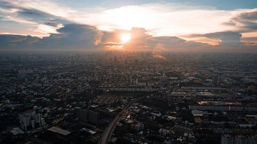 High angle view of illuminated cityscape against sky during sunset