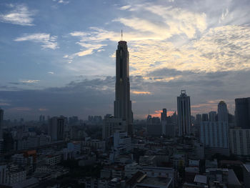 Modern buildings in city against sky during sunset