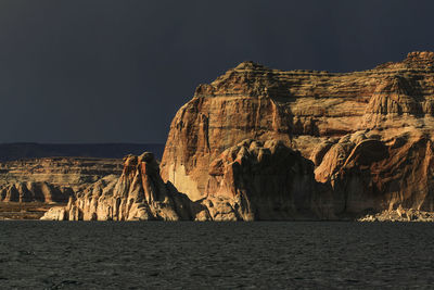 Panoramic shot of rocks by sea against sky