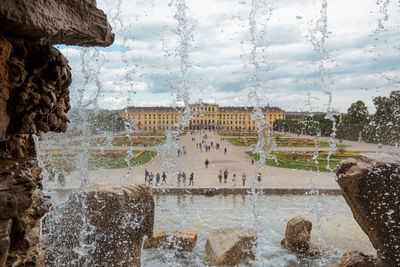 Fountain in city against sky