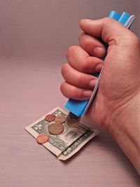 Close-up of hand holding eyeglasses against gray background