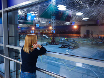 Side view of woman standing at illuminated nightclub