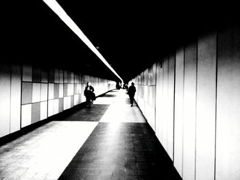 People in illuminated corridor