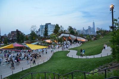Group of people in park against buildings in city