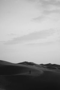 Silhouette person on desert against sky