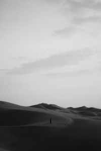 Silhouette person on desert against sky