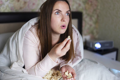 Portrait of young woman using mobile phone at home