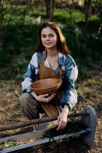 Portrait of young woman sitting in garden