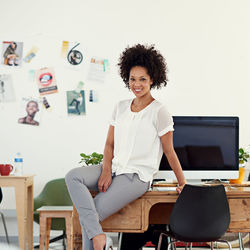 Portrait of businesswoman sitting on table
