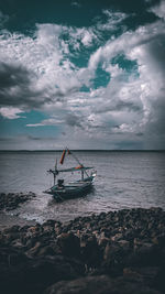 Fishing boat on sea against sky