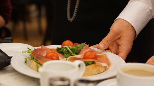 Midsection of person serving food on table