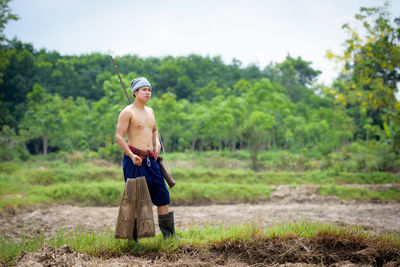 Portrait of shirtless man standing on land