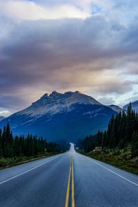 Road by mountains against sky
