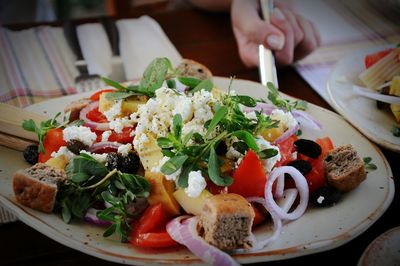 Close-up of fresh greek salad served in plate on table at restaurant