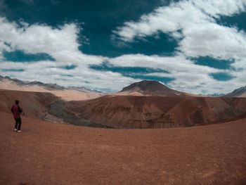 Rear view of man standing on landscape against sky