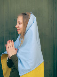 Young woman standing against wall