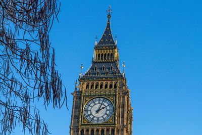 Low angle view of clock tower against blue sky