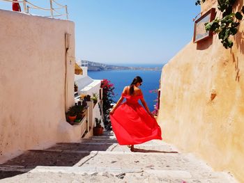 Rear view of woman walking on steps against sky