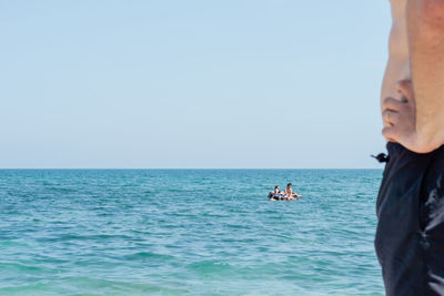 Man standing in sea against clear sky