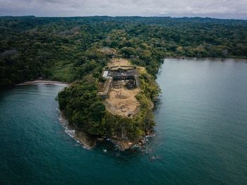 High angle view of abandoned building on cliff amidst sea