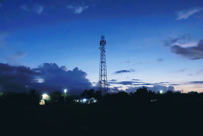 Low angle view of communications tower against sky at night