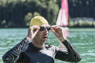 Male triathlete wearing goggles in river