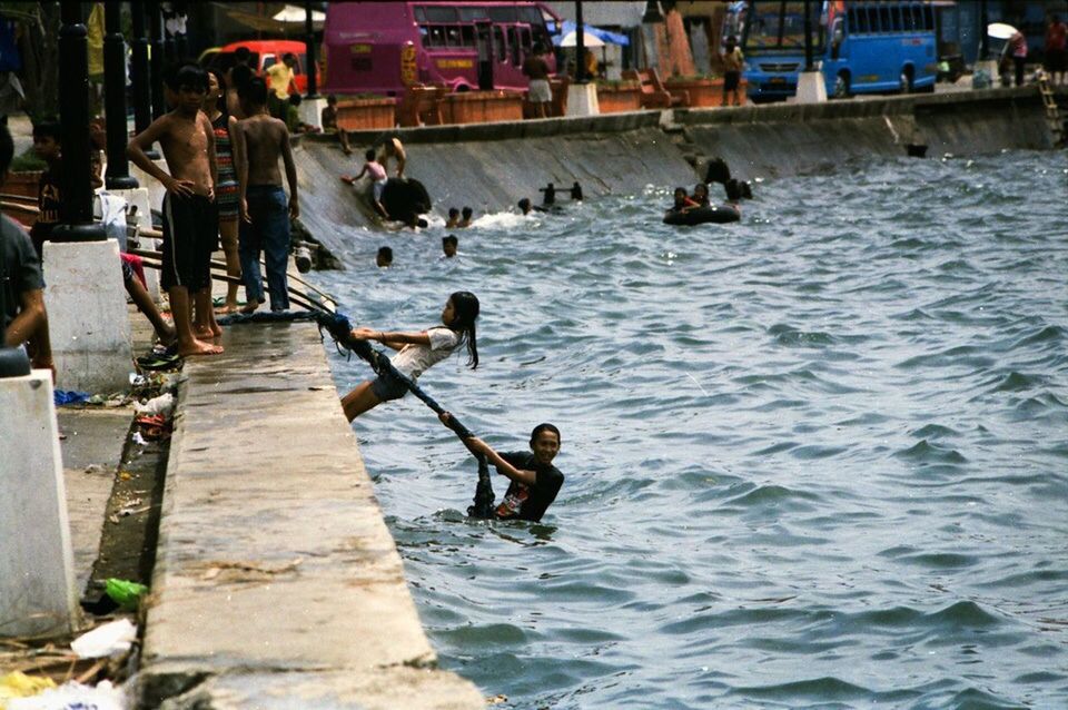 water, men, lifestyles, nautical vessel, leisure activity, transportation, mode of transport, person, sea, boat, waterfront, built structure, full length, day, river, outdoors, architecture, occupation