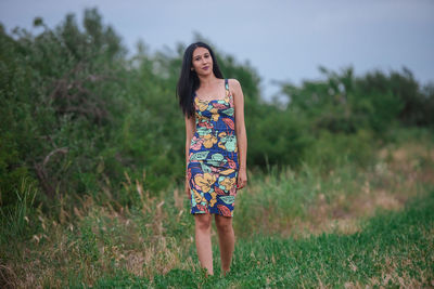 Portrait of young woman standing on grass