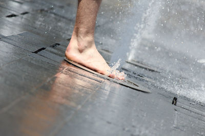 Low section of man stepping on fountain