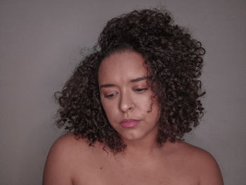 Portrait of beautiful young woman against gray background