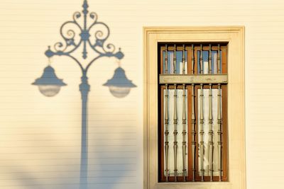 Close-up of window in building with a shadow of a street lamp 