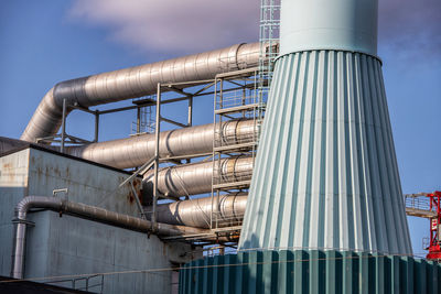 Low angle view of industry against sky