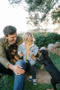 Side view of boy playing with dog