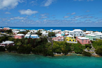 Houses by sea against blue sky